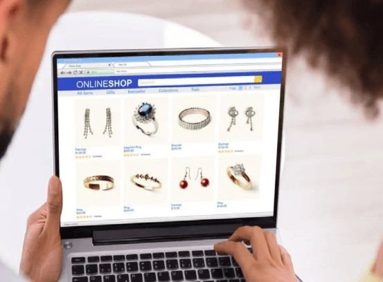 Two people browsing an online jewelry shop on a laptop